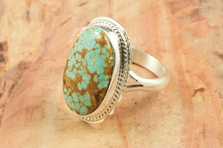 Genuine Number 8 Turquoise set in Sterling Silver Ring. The Number 8 mine is located in Eureka County Nevada. Since 1976 there has been no Number 8 Turquoise mined. There is however, an existing stock pile that Mr. Dowell Ward, the last owner of the Number 8 mine, had stocked away for later sorting. The Turquoise is a collector's item--because once the reserve is gone there will be no more material released onto the market. The Gold Mining Company owns the claim to the Number 8 mine and it has been swallowed up by the gold mining operations. This is some of the last Number 8 Turquoise to be had and will be a great addition to your collection. Created by Navajo Artist Larson Lee. Signed by the artist.